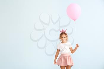 Little girl with balloon on color background�