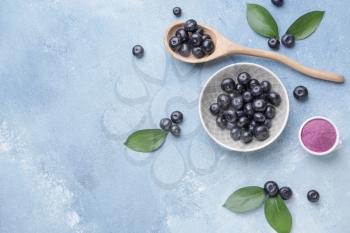 Acai berries with powder on color background�