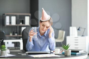 Young woman suffering from hangover in office�