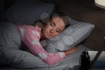 Young woman sleeping in bed at night�