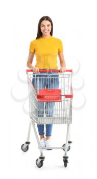 Young woman with empty shopping cart on white background�
