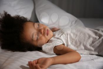Little African-American girl sleeping in bed at night�