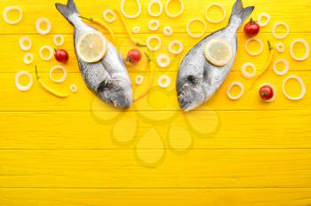 Raw dorado fish with vegetables on wooden background�