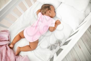 Little African-American baby sleeping in bed�