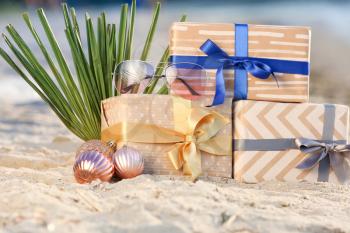 Gift boxes with balls on sea coast. Christmas vacation�