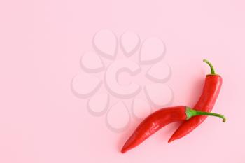Red chili peppers on color background�
