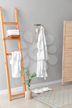 Clean bathrobe hanging on wall in room�