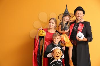 Family in Halloween costumes on color background�