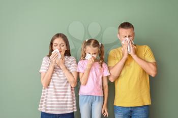 Family suffering from allergy on color background�