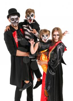 Family in Halloween costumes on white background�