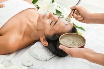 Beautiful woman undergoing treatment with facial mask in beauty salon�