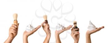 Hands with shaving brushes and foam on white background�