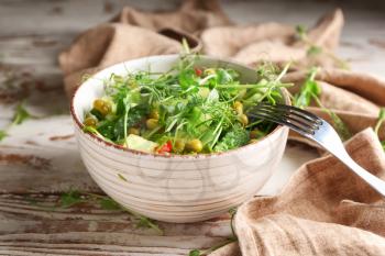 Bowl with fresh vegetable salad on wooden background�
