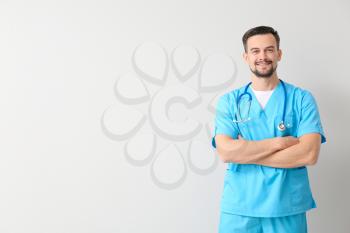 Portrait of male doctor on light background�