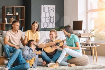 Group of friends listening to music at home�