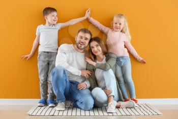 Portrait of happy family near color wall�