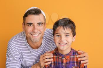 Portrait of Muslim man with son on color background�