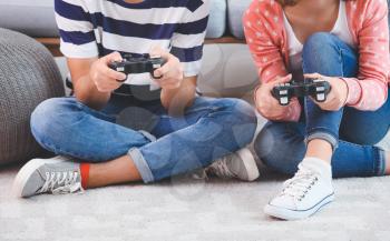 Teenagers playing video games at home�