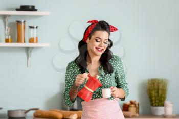 Portrait of beautiful pin-up woman with coffee in kitchen�