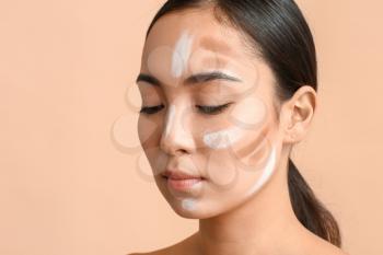 Young Asian woman with contouring makeup on color background�