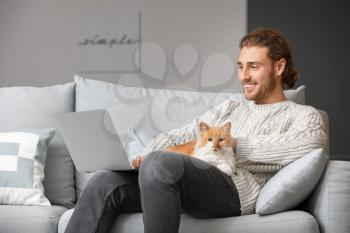 Man with laptop and his cute cat at home�