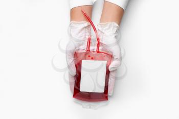 Hands of doctor with blood pack for transfusion on white background�