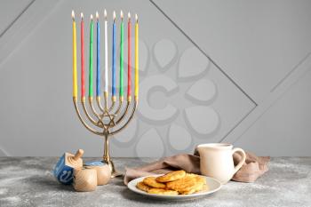 Menorah, potato pancakes and dreidels for Hanukkah on table�