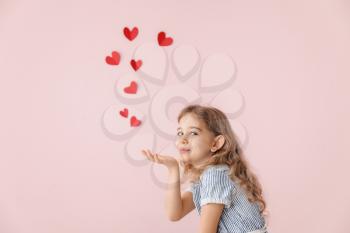 Cute little girl sending romantic air kiss on color background. Valentines Day celebration�