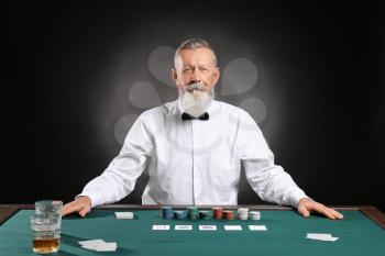 Mature male banker at table in casino�