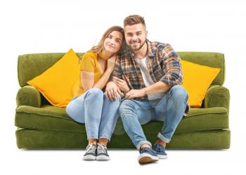 Young couple sitting on sofa against white background�