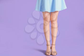 Legs of young woman in stylish shoes on color background�