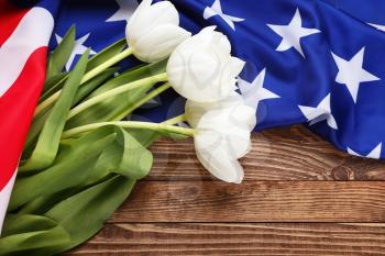 USA flag and flowers on wooden background. Memorial Day celebration�