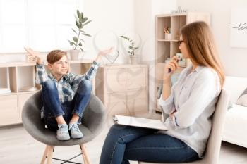 Female psychologist working with boy in office�