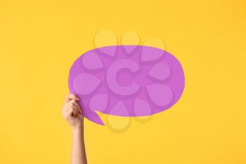 Female hand with blank speech bubble on color background�