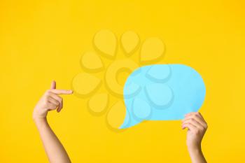 Female hands and blank speech bubble on color background�
