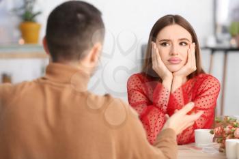 Sad woman listening to boring man on romantic date in cafe�