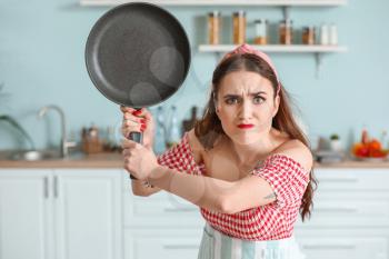 Funny angry housewife in kitchen�