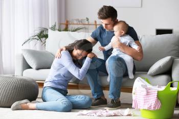 Stressed couple suffering from postnatal depression at home�