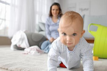 Cute baby and young woman suffering from postnatal depression at home�