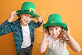 Funny little children on color background. St. Patrick's Day celebration�