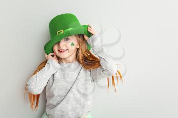 Funny little girl on white background. St. Patrick's Day celebration�