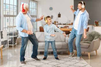 Man with his father and son listening to music at home�
