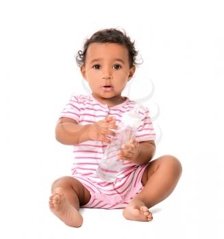 Cute African-American baby with bottle of water on white background�