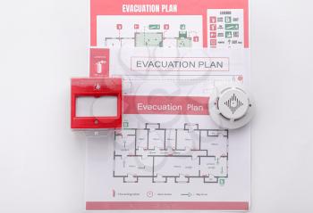 Evacuation plans, smoke detector and manual call point on white background�