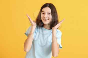 Teenage girl with dental braces on color background�