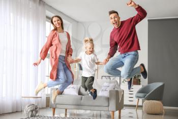 Happy family jumping at home�