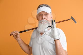 Sporty elderly golf player on color background�