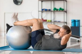 Sporty elderly man training in gym�