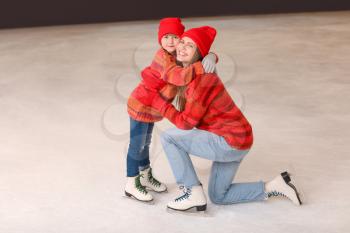 Young mother with little daughter on skating rink�