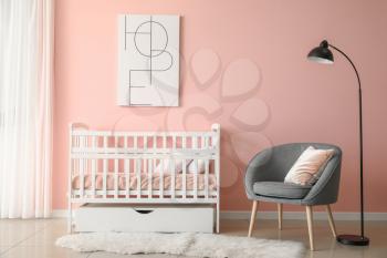Baby bed with armchair in interior of children's room�